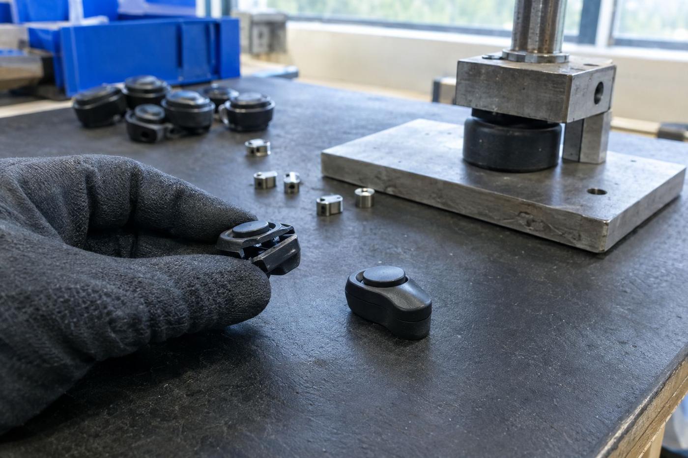 Tiny overmoulded button assemblies compared on an anti-static bench mat